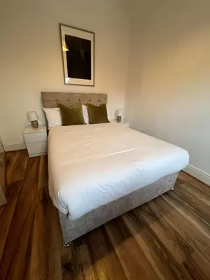 a bedroom with a bed with white sheets and green pillows at 2025 Award Winner Liverpool Ivy House - 4 Bedrooms in Liverpool