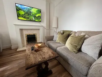 a living room with a couch and a tv on the wall at 2025 Award Winner Liverpool Ivy House - 4 Bedrooms in Liverpool