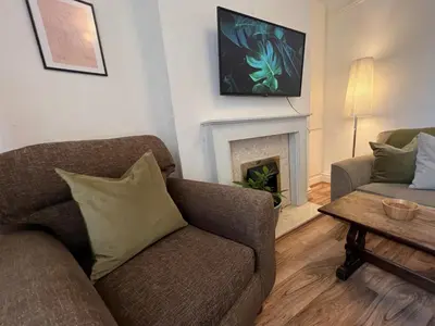 a living room with a couch and a fireplace at 2025 Award Winner Liverpool Ivy House - 4 Bedrooms in Liverpool