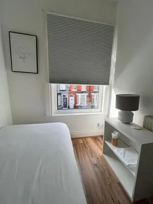 a bedroom with a bed and a window with a blind at 2025 Award Winner Liverpool Ivy House - 4 Bedrooms in Liverpool