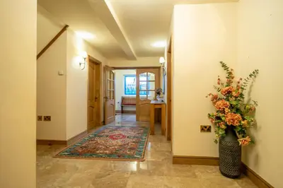 a hallway with a vase of flowers on the wall at Heron House in Haverigg