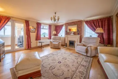 a living room with a couch and chairs and a fireplace at Heron House in Haverigg