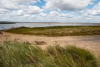 a group of people on a beach near a body of water at Heron House in Haverigg