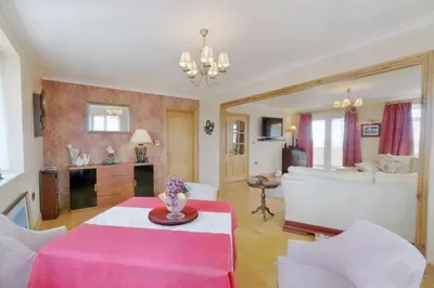 a living room with a pink table and a couch at Heron House in Haverigg