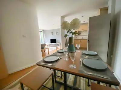 a dining room table with a vase of flowers on it at Liverpool One Beautifully Presented 2 Bedroom Apartment in Liverpool