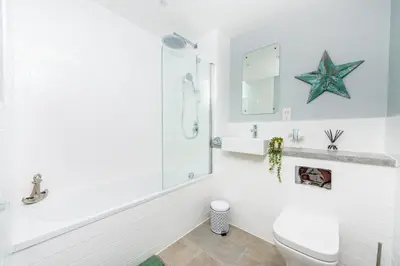 a white bathroom with a starfish on the wall at Brand New Stunning City Centre Open Plan 1Bed in Liverpool