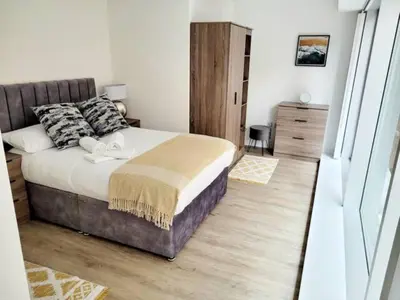 a bedroom with a large bed and a wooden floor at Brand New Stunning City Centre Open Plan 1Bed in Liverpool