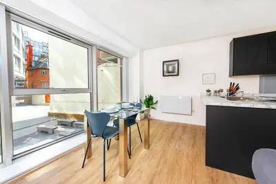 a kitchen and dining room with a table and a large window at Brand New Stunning City Centre Open Plan 1Bed in Liverpool