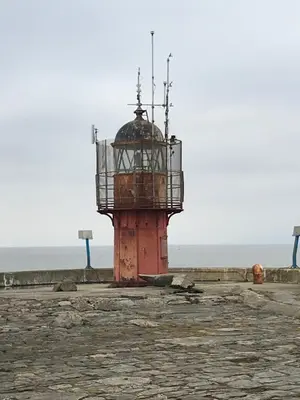 a lighthouse on the beach with the ocean in the background at Bobby's Bolthole in Heysham
