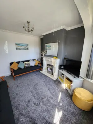 a living room with a couch and a fireplace at Delightful newly renovated 3-bed house with garden beach hut in Blackpool