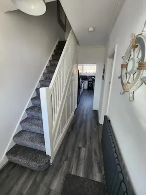 a staircase in a home with white walls and wood floors at Delightful newly renovated 3-bed house with garden beach hut in Blackpool