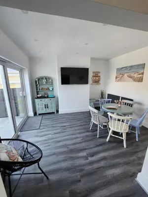 a living room with a table and chairs at Delightful newly renovated 3-bed house with garden beach hut in Blackpool