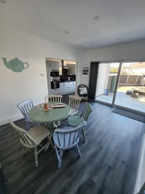 a living room with a table and chairs and a kitchen at Delightful newly renovated 3-bed house with garden beach hut in Blackpool