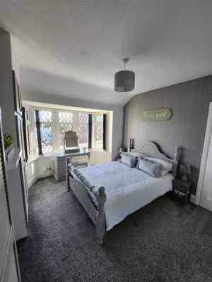 a bedroom with a bed with white sheets and pillows at Delightful newly renovated 3-bed house with garden beach hut in Blackpool