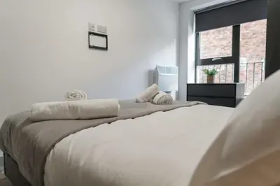 a white bedroom with a large bed and a window at Contemporary 1 Bed Apartment in Liverpool Centre in Liverpool