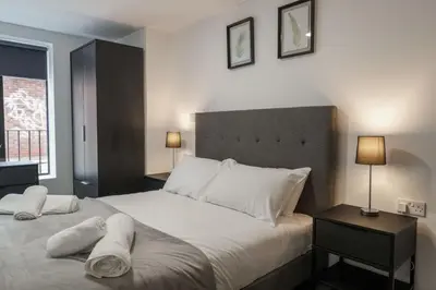 a bedroom with a large bed with white sheets and pillows at Contemporary 1 Bed Apartment in Liverpool Centre in Liverpool