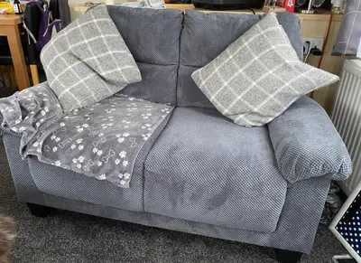 a gray couch with two pillows on top of it at Bobbys Bolthole2 in Heysham