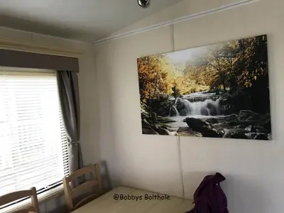 a painting of a waterfall hanging on a wall at Bobbys Bolthole2 in Heysham