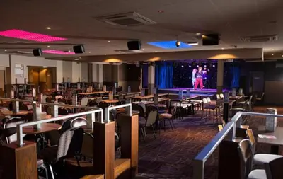 a dining room with tables and chairs and a stage at Bobbys Bolthole2 in Heysham