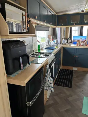 a kitchen with blue cabinets and a stove top oven at Bobbys Bolthole2 in Heysham