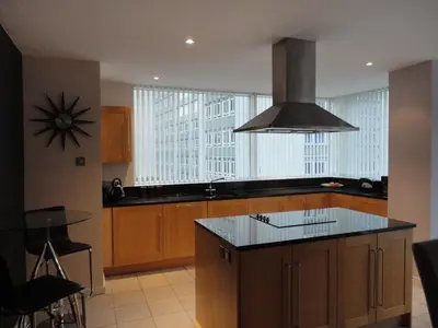 a kitchen with a island with a stove top oven at Luxury Apartment Best location in Liverpool city center in Liverpool