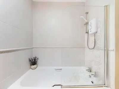a white bathroom with a shower and a sink at Magnificent 1BDR Apartment in Mersyside in Liverpool