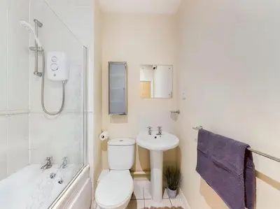 a bathroom with a toilet and a sink and a tub at Magnificent 1BDR Apartment in Mersyside in Liverpool