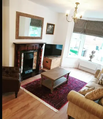 a living room with a couch and a fireplace at Dora Cottage in Formby
