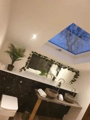 a bathroom with a sink and a window and a toilet at Dora Cottage in Formby