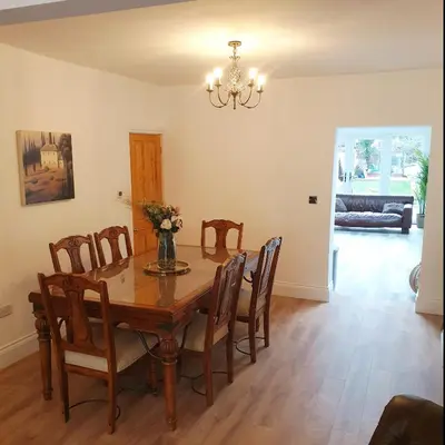 a dining room with a wooden table and chairs at Dora Cottage in Formby