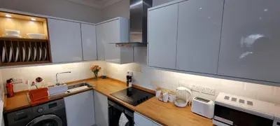 a kitchen with white cabinets and a washer and dryer at Lakeview Apartment, central location, Sea and Lake view, free parking & WiFi in Southport