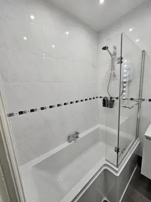 a white bathroom with a shower and a tub at Lakeview Apartment, central location, Sea and Lake view, free parking & WiFi in Southport