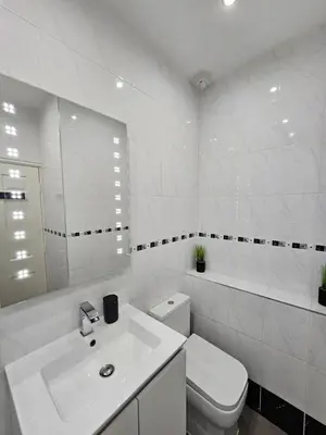 a white bathroom with a toilet and a sink at Lakeview Apartment, central location, Sea and Lake view, free parking & WiFi in Southport