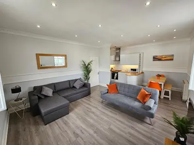 a living room with two couches and a kitchen at Lakeview Apartment, central location, Sea and Lake view, free parking & WiFi in Southport