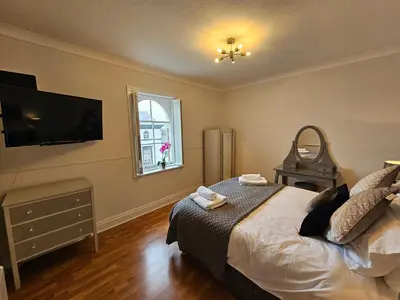 a bedroom with a bed and a flat screen tv at Lakeview Apartment, central location, Sea and Lake view, free parking & WiFi in Southport