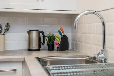 a kitchen counter with a sink and utensils at Fabulous Quayside Apartment with Free Parking in Liverpool