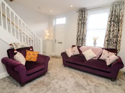 a living room with a couch and a chair at Myrtle Cottage in Preston
