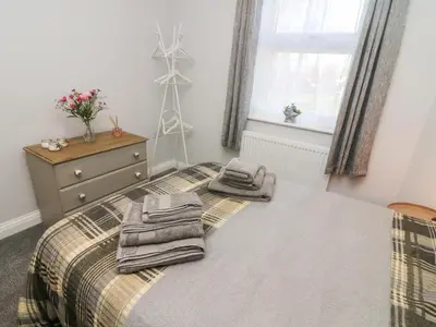 a bedroom with a bed with towels on it at Myrtle Cottage in Preston