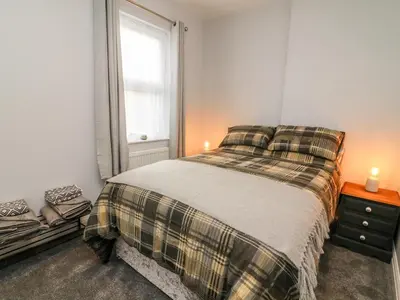 a small bedroom with a bed and a window at Myrtle Cottage in Preston
