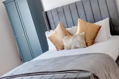 a bedroom with a large bed with pillows at 80 by Elite in Liverpool