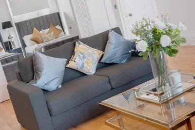a living room with a couch with pillows and a table at 80 by Elite in Liverpool