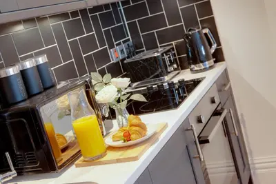 a kitchen counter with a plate of food and orange juice at 80 by Elite in Liverpool