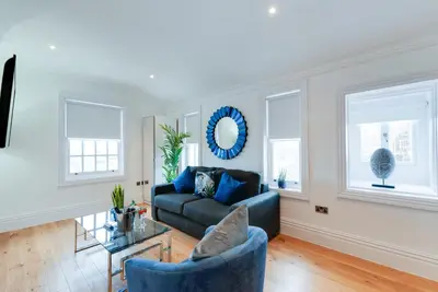 a living room with a couch and windows at 80 by Elite in Liverpool