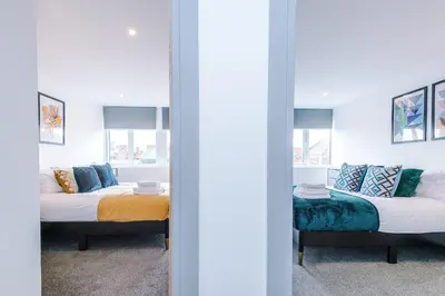 two beds in a room with a mirror at Charles House by Guestz in Preston