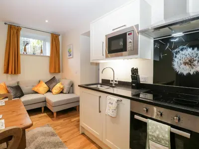 a kitchen and a living room with a couch at Granary in Ulverston