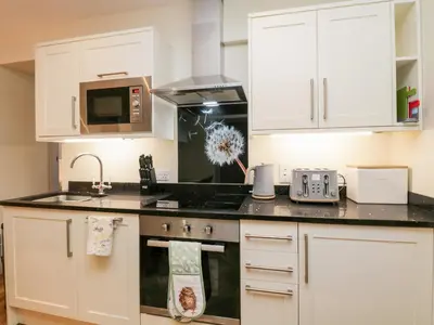 a kitchen with white cabinets and a stove top oven at Granary in Ulverston