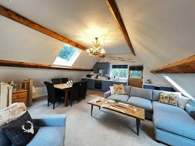 a living room with a couch and a table at Cosy Alpine Cottage in the heart of Lancashire in Catterall