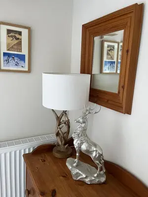 a lamp on top of a table with a mirror at Cosy Alpine Cottage in the heart of Lancashire in Catterall