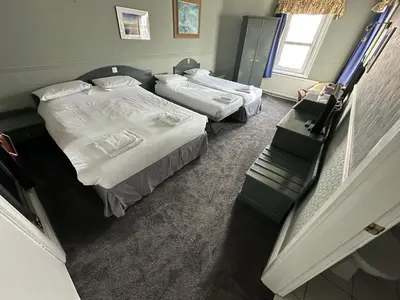 a bedroom with two beds and a window at Clarkes Hotel Barrow in Furness in Barrow in Furness