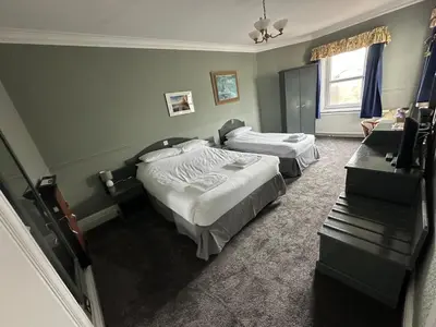 a hotel room with two beds and a window at Clarkes Hotel Barrow in Furness in Barrow in Furness